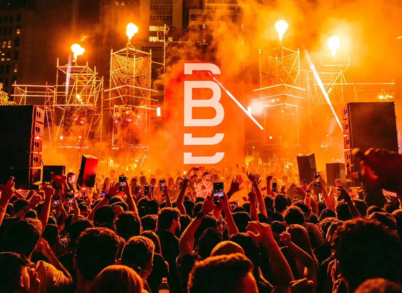 Público diante do palco iluminado em vermelho durante o BOMA